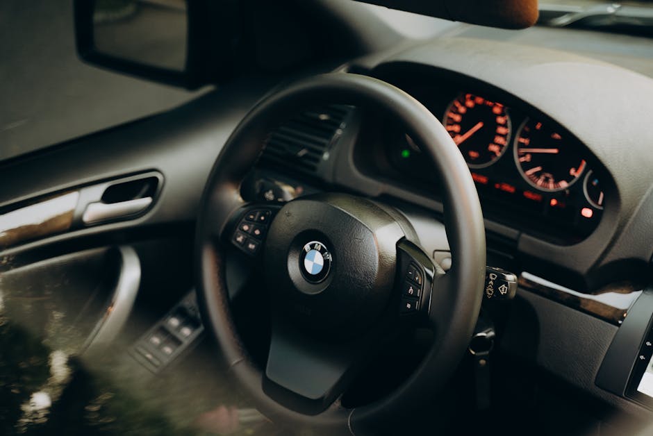 pexels-photo-13179060-13179060 Explore the elegance of a luxurious BMW interior featuring a sleek dashboard and steering wheel.